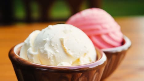 vanilla and strawberry ice cream scoops in wooden bowls