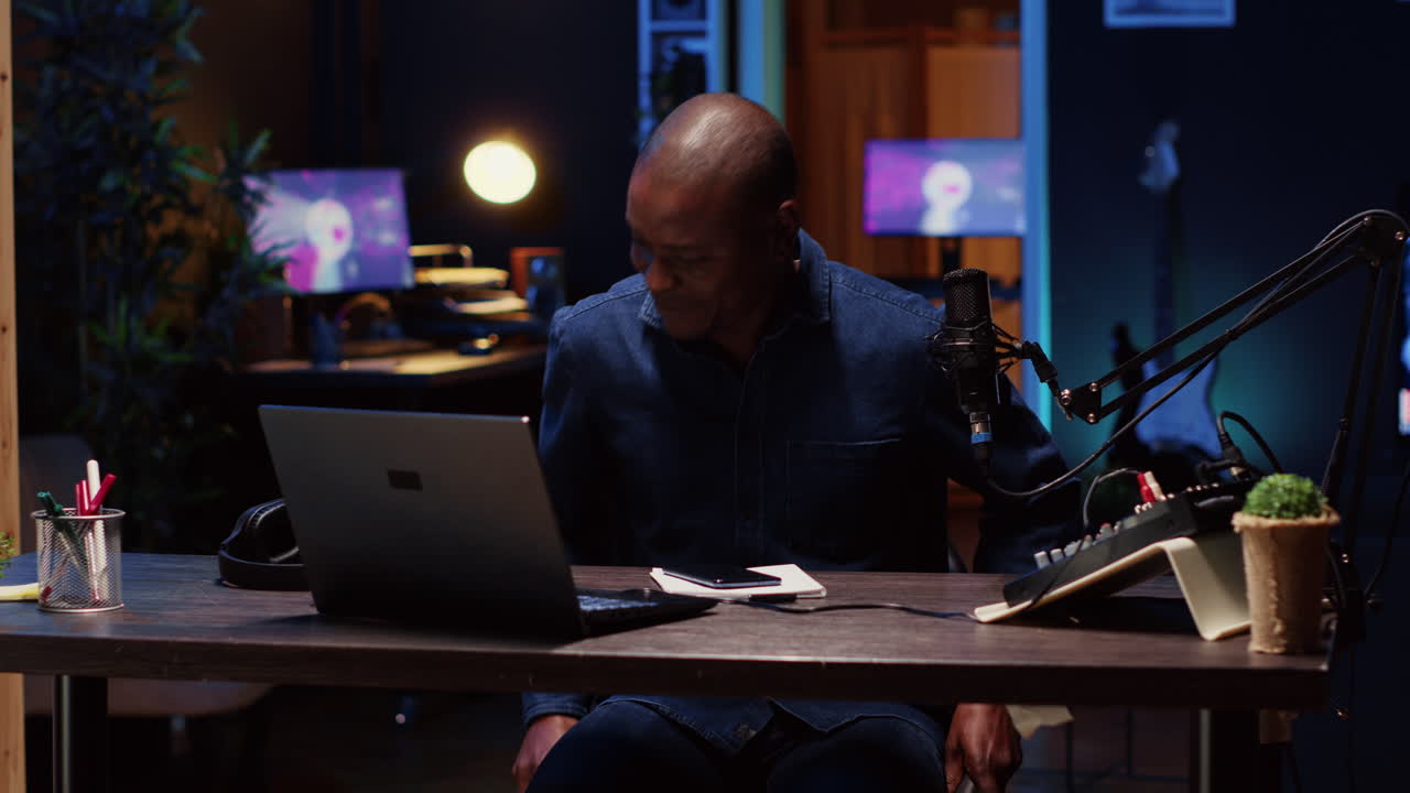 uomo che arriva in studio, saluta il pubblico, trasmette in diretta utilizzando strumenti professionali