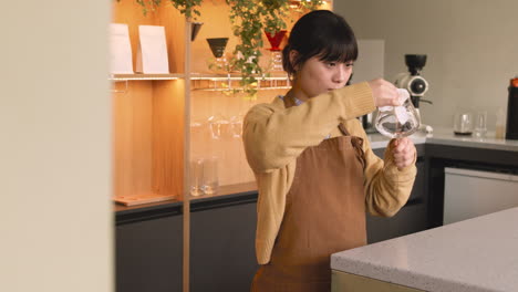 camarera sosteniendo y limpiando una copa de vino con un paño