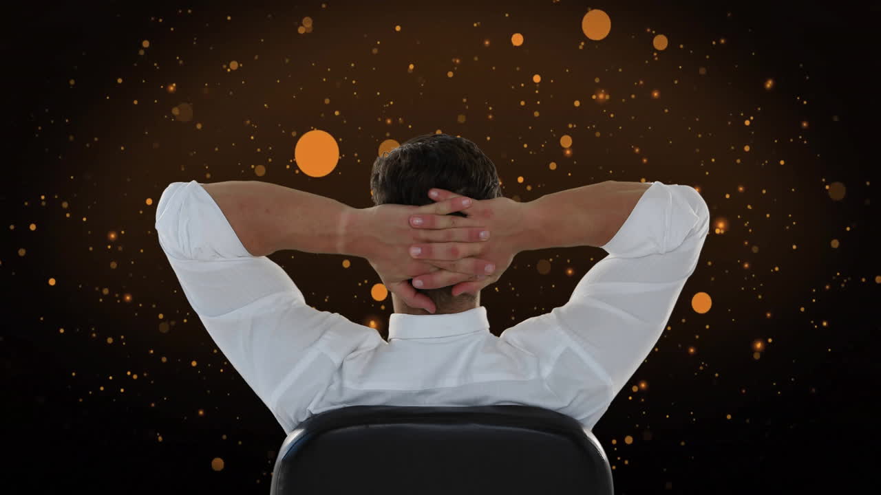 Man relaxing in chair with hands behind head over golden sparkles animation
