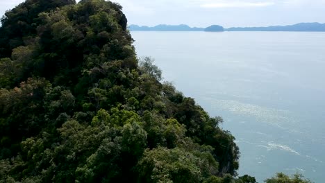 Flying-over-a-mountain-with-limestone-and-the-ocean-on-the-background