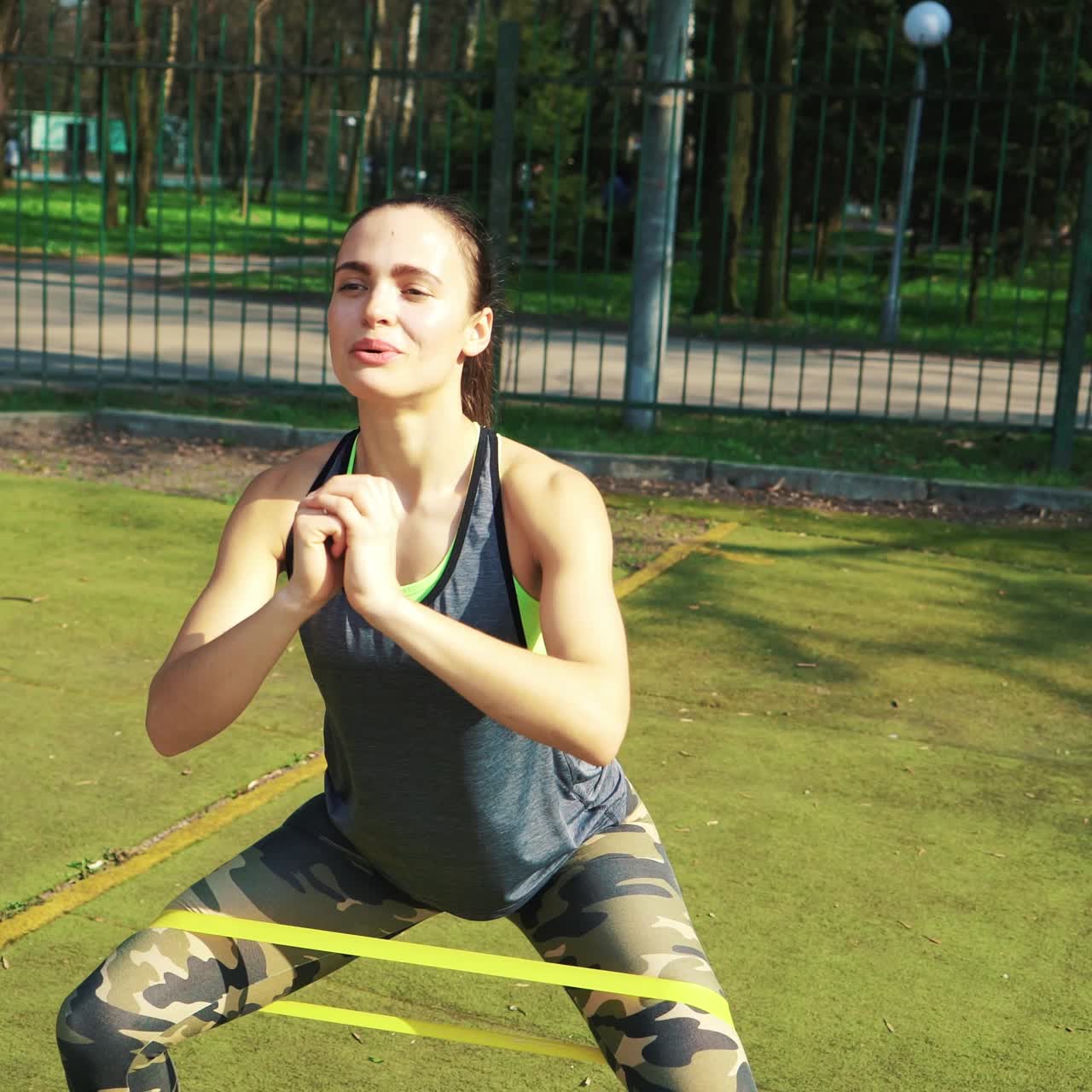 Sporty woman doing stretching exercises outdoor. Fitness girl doing lunges in park at summer. Workout at sunny day.