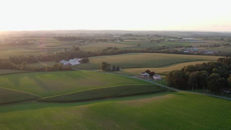 aerial pullback reveals rolling hills, green farmland in countryside