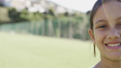 Biracial-girl-smiles-brightly-in-a-sunny-outdoor-setting