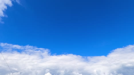 Cumulus clouds gathered in the azure sky. Rainy cloudscape forming in the summer sky. Low angle view. Timelapse.