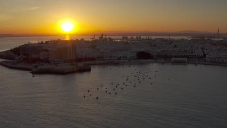 sunset over coastal town with harbor and boats