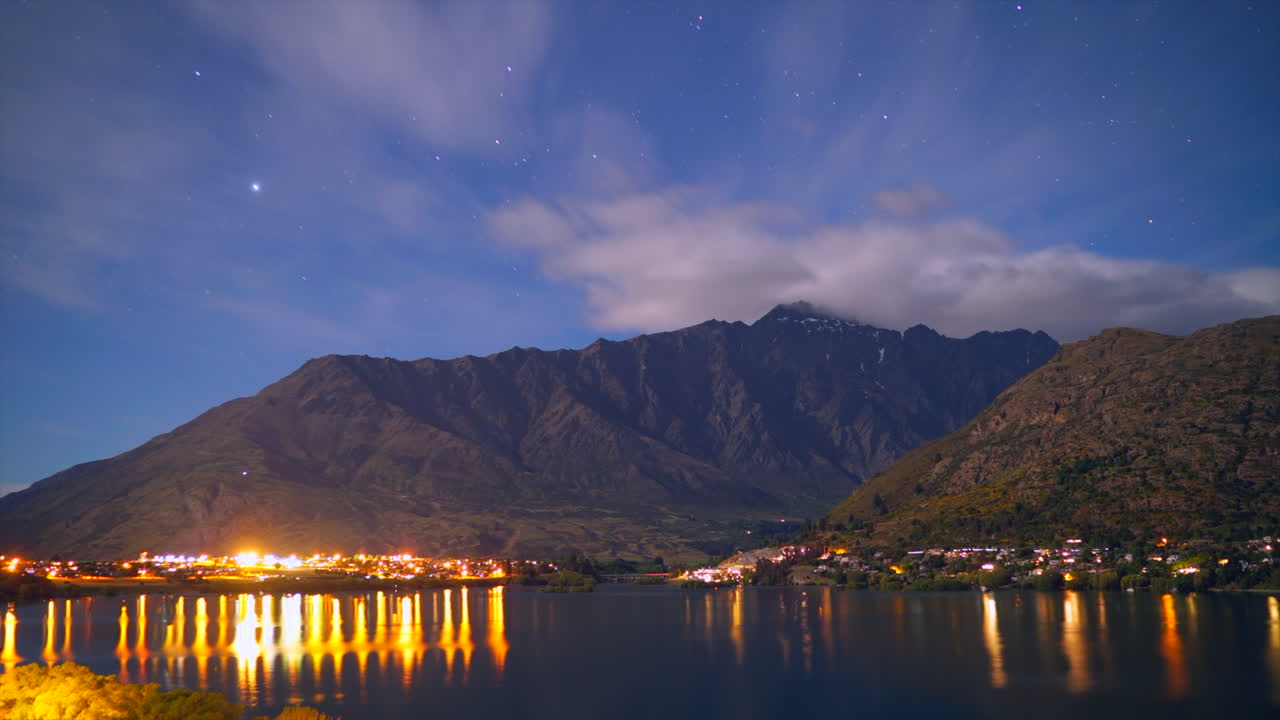 Cirri in movimento sopra le montagne mentre le stelle brillano di notte