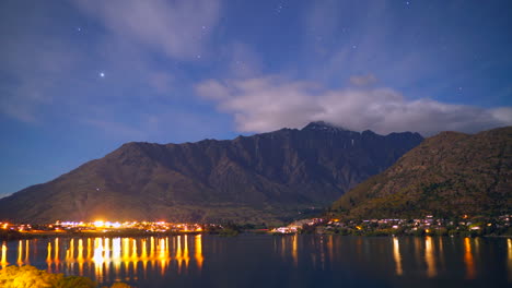 nubes cirros moviéndose sobre montañas mientras los comienzos brillan por la noche