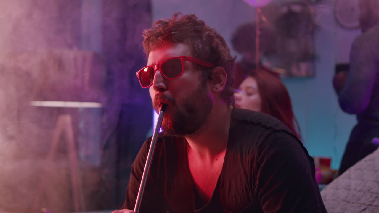 Friends enjoying hookah in a colorful party setting