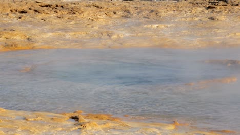 close-up view of starting of eruption of hot spring strokkur in icelandic valley of geysers