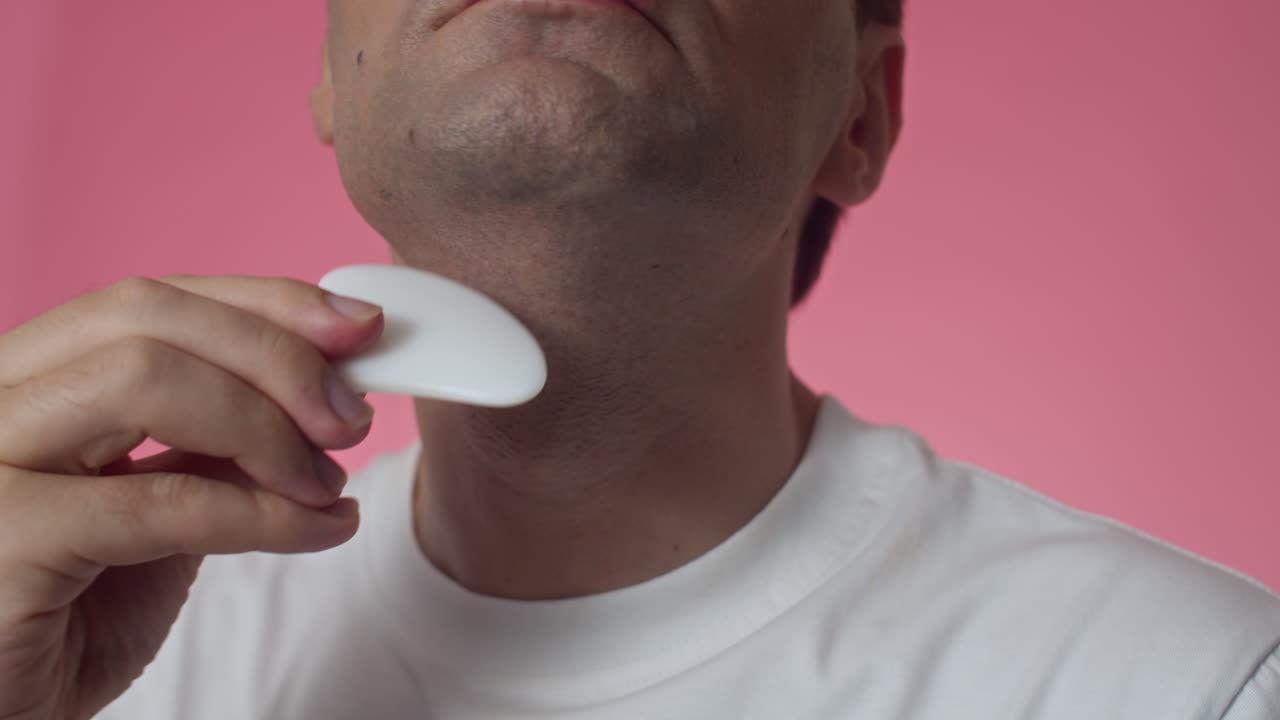 Man Massaging Neck Using Gua Sha Tool