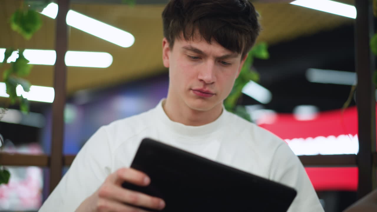 Serious teenager intently staring at phone screen with warm radiance of backlight pouring through window framing focused profile conveying mood of contemplation and digital absorption in glow