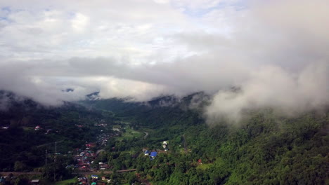 vista aérea volando a través de la mañana lluvia cubierta de nubes selva tropical paisaje montañoso durante la temporada de lluvias en el parque nacional reservado de la montaña doi phuka el norte de tailandia