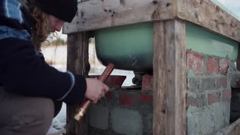 the man is fitting a pipe to the diy hot tub - close up