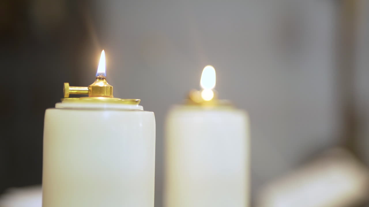 Primo piano di due lampade a olio bianche con fiamme tremolanti