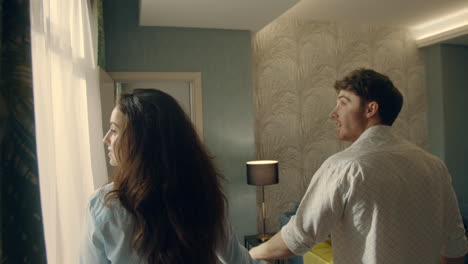 cute man and woman looking around in hotel room