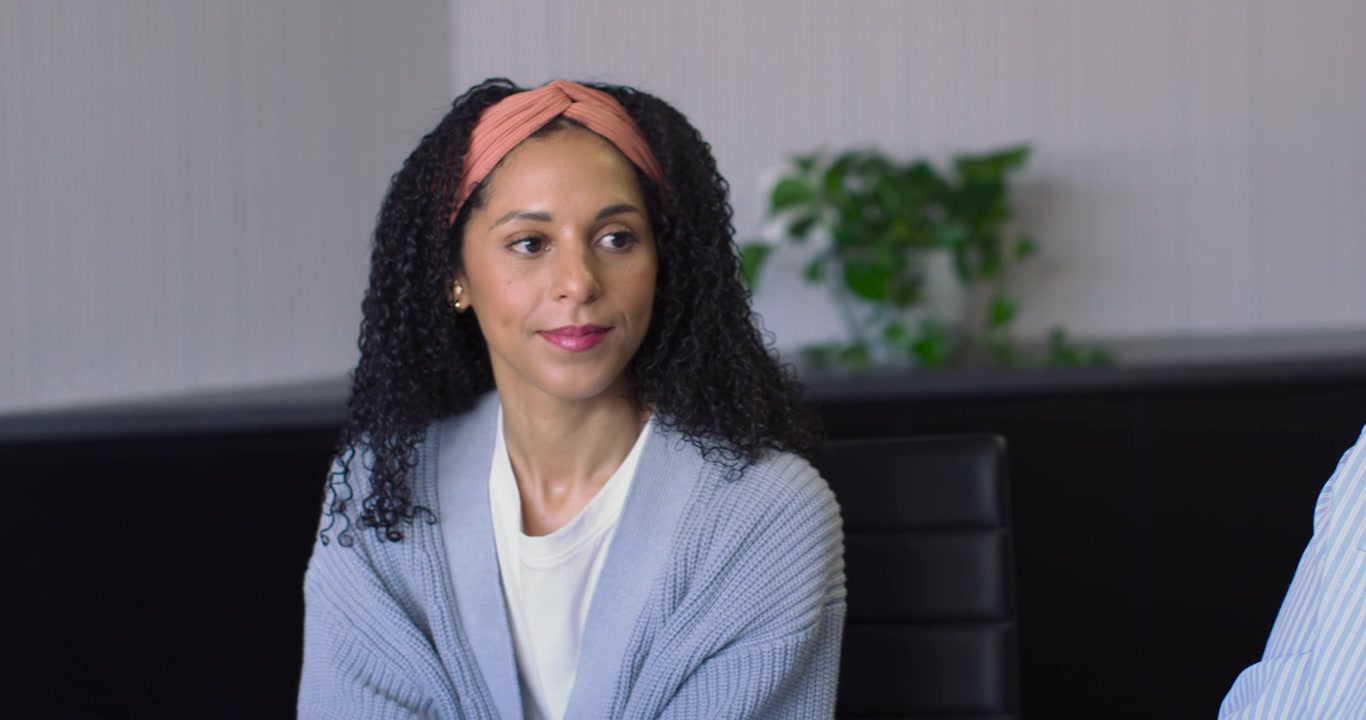 Donne afroamericane spostano l'attenzione durante una riunione mentre la telecamera si allarga, la donna B sistema la fascia