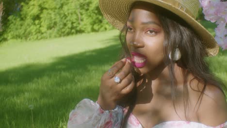 Black-Woman-eating-grapes-and-looking-around-in-the-park