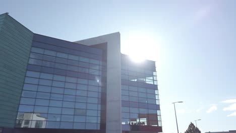 modern glass office building reflection blue sky sunshine cityscape architecture push in