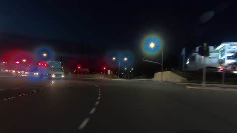 rear facing night driving point of view pov for interior car scene green screen replacement - well-lit suburban city roads with small amount of traffic