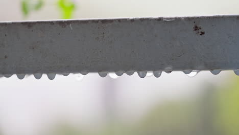 a close-up of rainwater dripping on a metal handle during heavy rain