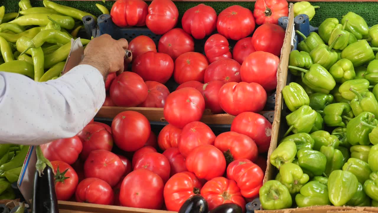 농산물 스탠드 에서 토마토 를 뽑는 사람