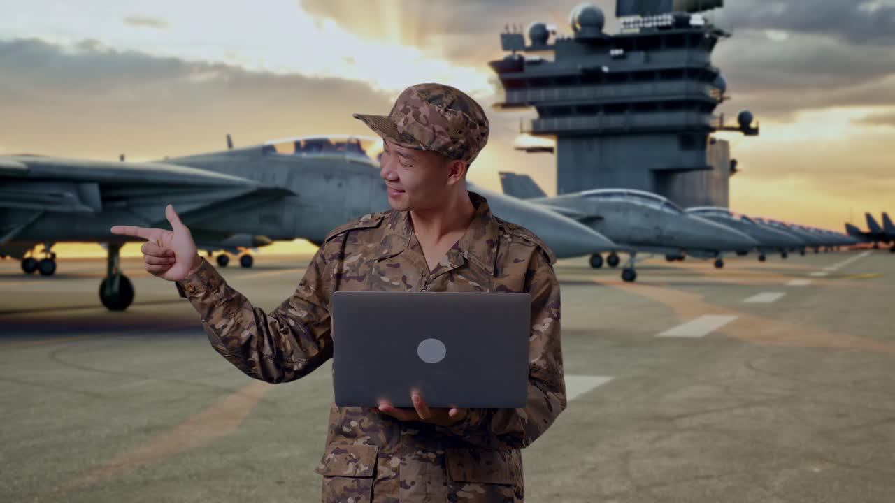 Military Personnel with Laptop on Aircraft Carrier Deck at Sunset