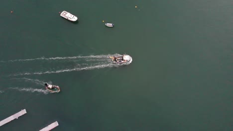 Aerial-overhead-shot-of-Fishing-boats-heading-out-of-Lyme-Regis-Dorset-England-on-an-early-morning