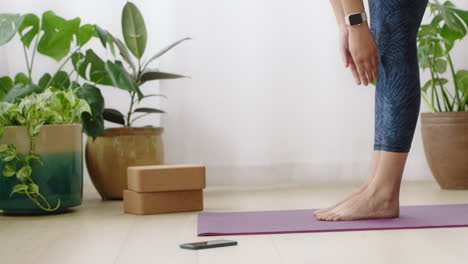 attractive yoga woman exercising healthy lifestyle practicing standing forward bend pose enjoying workout at home training on exercise mat