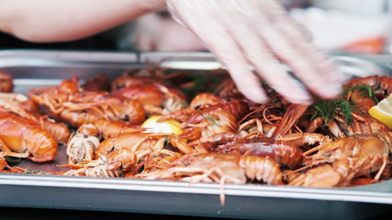 Cook filling plateau with cooked crayfish. Food festival