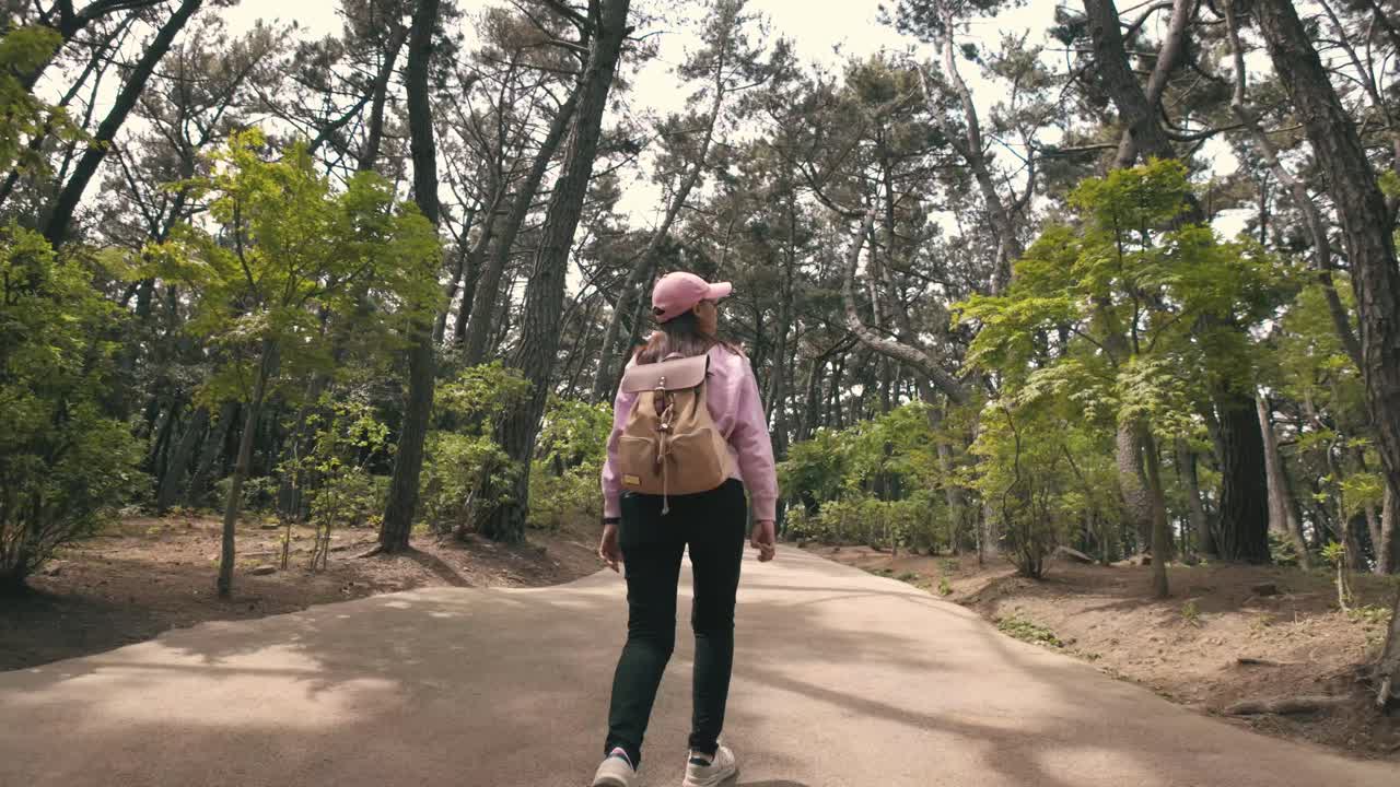 una niña caminando tranquilamente por un camino bordeado de flores vibrantes y a través de un bosque exuberante, encapsulando la esencia de un tranquilo retiro en la naturaleza