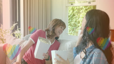 eating popcorn and laughing, two women with rainbow heart animation