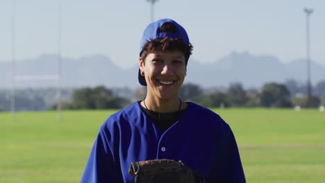 portrait of happy caucasian female baseball player, on field smiling