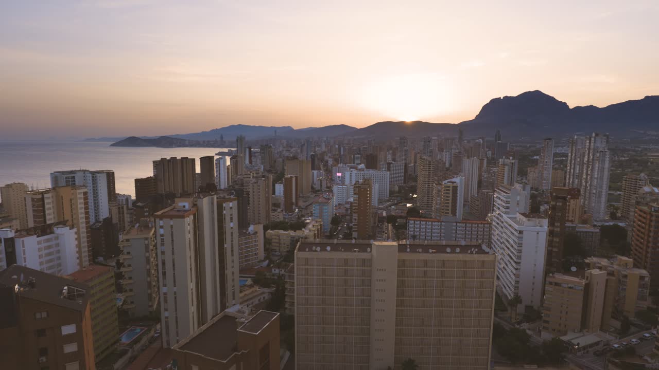 Amplo panorama aéreo da paisagem urbana de Benidorm com arranha-céus ao pôr do sol