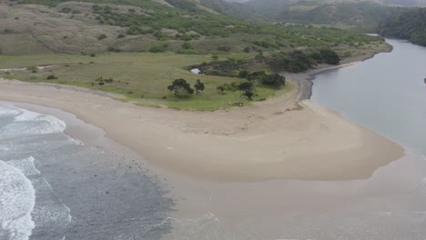 aerial of ocean separating with sand exposed in middle, transkei rolling hills in background