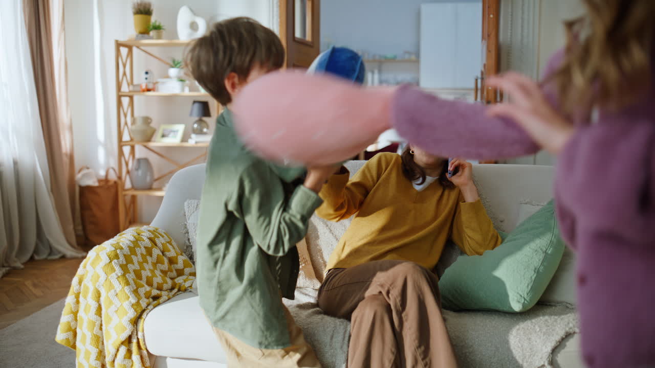Two kids hiding sofa playing shelter closeup. Mother talking mobile phone call