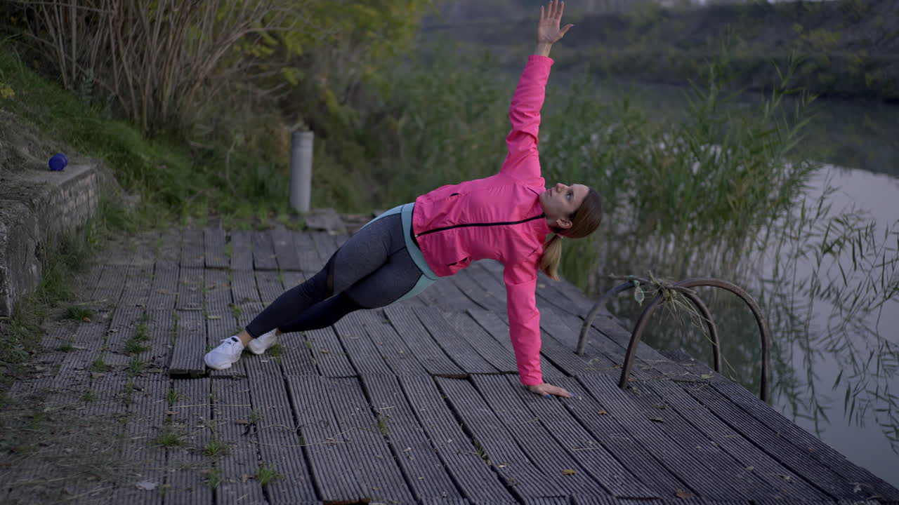Woman Doing Plank Exercises on a Wooden Dock