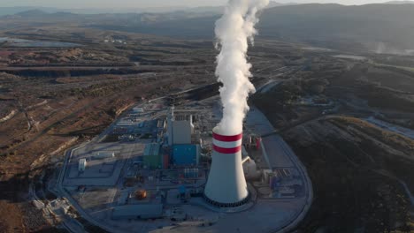 drone steam come from a coal fired power station chimney tilting down sunset