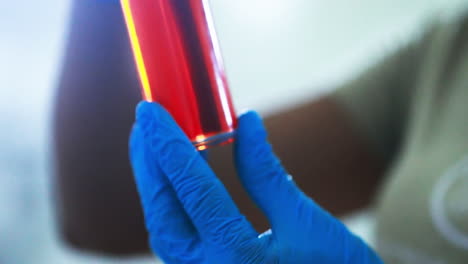 primer plano de un científico inspeccionando una botella de aceite de palma de macauba purificado
