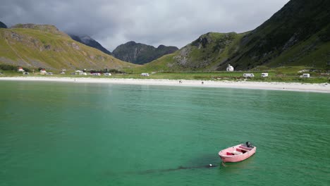 Boat-floats-in-Arctic-Sea-at-Haukland-Beach,-Lofoten-Islands,-Norway