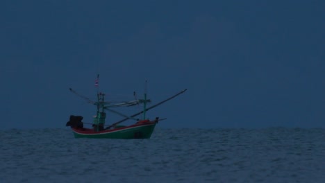 fishing boats in thailand wait in the middle of the ocean for dark to come so they can turn on their green lights and start fishing and troll for shrimps