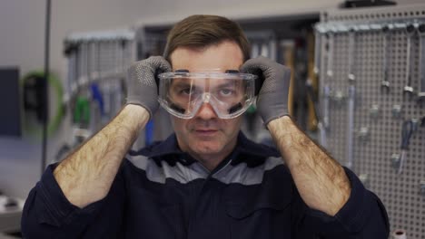 a car mechanic putting on protection glasses