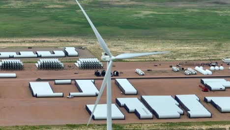 wind turbine spinning at manufacturing site of windmill blades and other parts