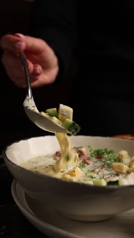 woman eating cold russian soup (okroshka)