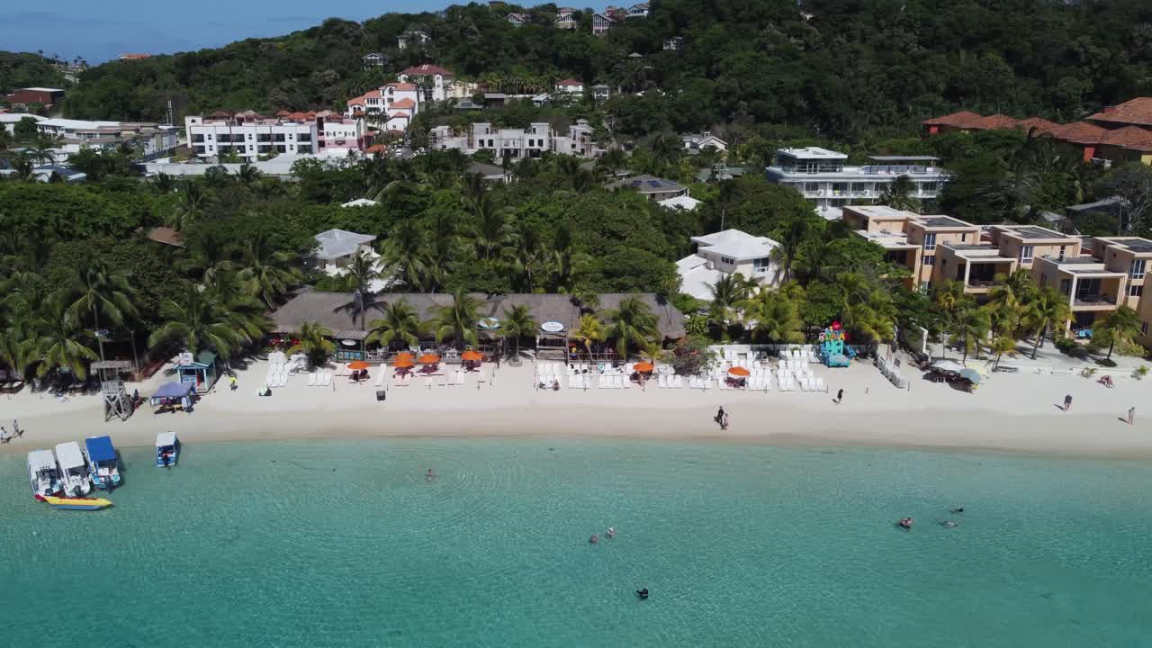 roatan, hnd의 파우더 화이트 열대 관광 해변을 따라 공중 돌리