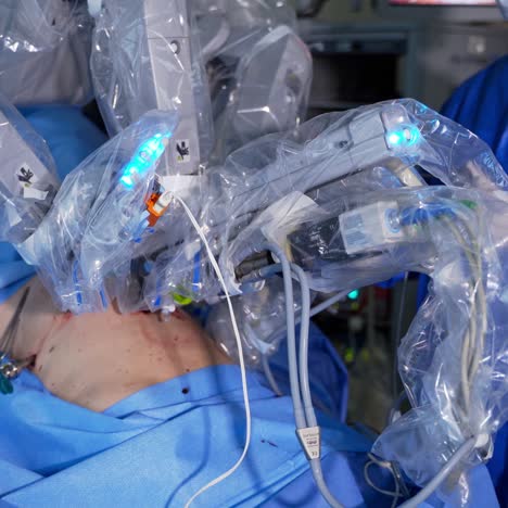 futuristic surgery equipment operating the patient. robotic arm moving slowly during the surgery. surgeon standing behind the operating table