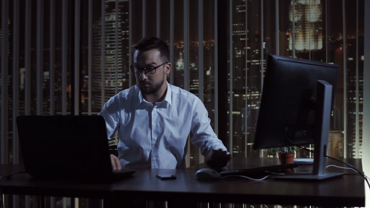 Businessman Working Late at Night in a Modern Office with City Skyline View