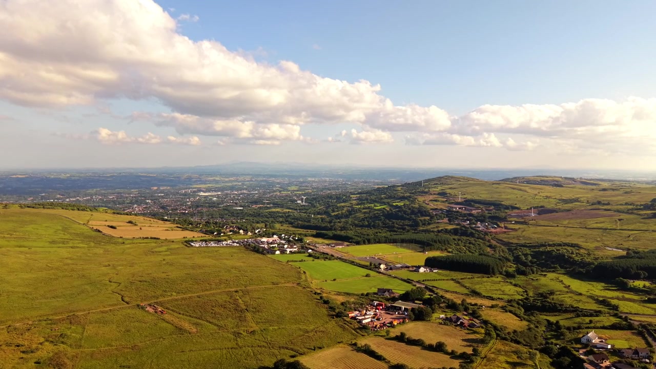 Bred fremadskridende 4K 60FPS luftvideo af Black Mountain og Divis Mountain i West Belfast, Nordirland i Storbritannien på en lys solskinsdag. Produceret med Rec709 farve