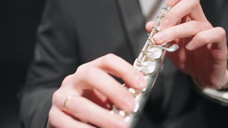 flute in hands of flutist closeup view musician in orchestra brass band on rehearsing or concert