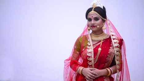 isolated indian bengali bride wearing red saree smiles against white background